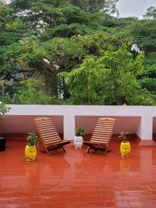 two chairs and potted plants sitting on a patio at Pearl - Sunflower Skyline in Bangalore
