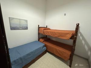 a room with two bunk beds and a picture at Casa grande 3 dormitorios playa alvorada in Barra del Chuy