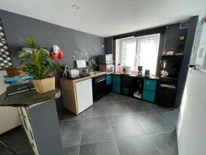 a kitchen with black walls and a white refrigerator at Logement du Paquis in Les Mazures +5 photos