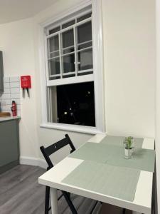 a white table and chair in a kitchen with a window at Room 3 • Double Bed in London King’s Cross in London
