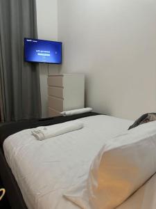 a bedroom with a bed with a tv on the wall at Room 3 • Double Bed in London King’s Cross in London