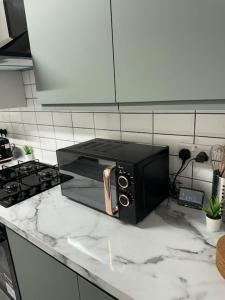 a black microwave sitting on a counter in a kitchen at Room 3 • Double Bed in London King’s Cross in London