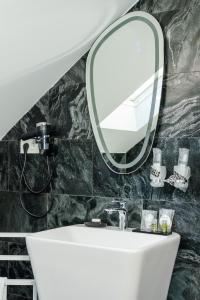 een badkamer met een wastafel en een spiegel bij D&D Relax SPA Bucovina in Câmpulung Moldovenesc