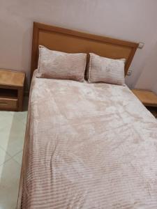 a bed with two pillows on top of it at Al-Nasr in Agadir