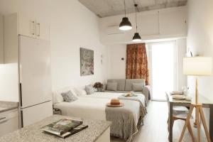 a white room with a bed and a table at Apartamentos RG Hospital Valme in Seville