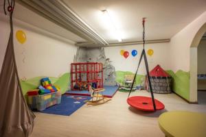 uma sala de jogos para crianças com um conjunto de jogos e brinquedos em Chiemgau Comfort A8 Ferienwohnanlage Oberaudorf mit Hallenbad und Sauna em Oberaudorf