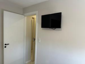 TV de pantalla plana colgada en una pared blanca en Hotel Bermudas en Mar del Plata