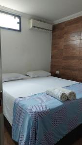 a bedroom with a bed with two towels on it at Casa de amigos e parentes in Eunápolis