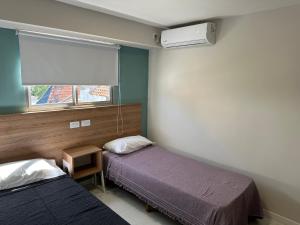 a bedroom with two beds and a window and a window at Hotel Bermudas in Mar del Plata