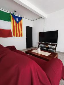 a living room with a flag and a television at 777 LENDERMAN BnB 777 in Cancún