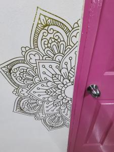 una puerta rosa con un diseño mandala en una pared en 777 LENDERMAN BnB 777, en Cancún