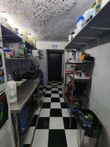 a kitchen with a black and white checkered floor at 777 LENDERMAN BnB 777 in Cancún