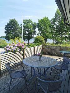 einen Tisch und Stühle auf einer Terrasse mit Blumen in der Unterkunft Gästhus nära havet in Kalmar