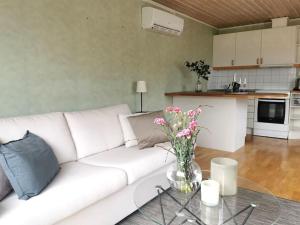 uma sala de estar com um sofá branco e uma mesa com flores em Gästhus nära havet em Kalmar