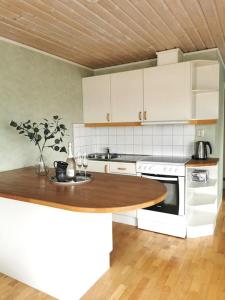 a kitchen with a wooden table and a counter top at Gästhus nära havet in Kalmar