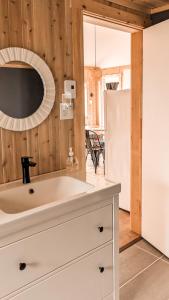 eine Küche mit einem weißen Waschbecken und einem Kühlschrank in der Unterkunft Le Martin Pecheur 2 chambres in Nouvelle