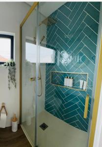 a bathroom with a shower with a blue tiled wall at Casa Sol in Lavra