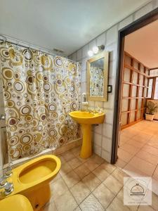 a bathroom with a yellow toilet and a sink at Departamento Plaza Independencia con terraza, kilometro cero Mendoza in Mendoza