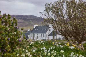 a white house with a mountain in the background at Monkstadt 1745 Restaurant with Rooms in Portree