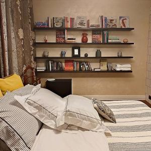 1 dormitorio con 1 cama con una estantería de libros en Henri Benoît maison d'hôtes гостьовий будинок en Horenka