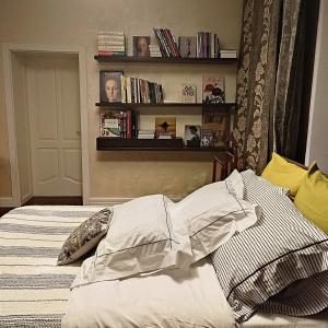 ein Schlafzimmer mit einem Bett und einem Regal mit Büchern in der Unterkunft Henri Benoît maison d'hôtes гостьовий будинок in Horenka
