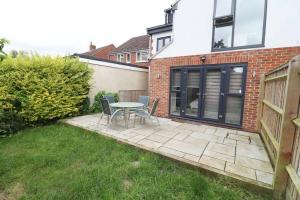 a patio with a table and chairs in a yard at Horizon House, Luxury 2-Bedroom Flat 3 in Oxford