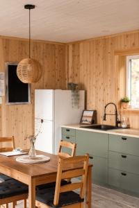 a kitchen with a table and chairs and a refrigerator at Chalet La Renarde in Nouvelle