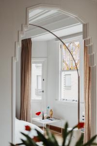 espejo en una habitación con mesa y ventana en Huis Hector Mechiels, en Sint-Niklaas