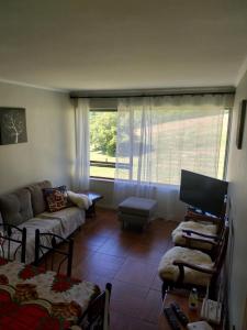 sala de estar con sofá y ventana en Departamento Playa Pto Montt, en Puerto Montt