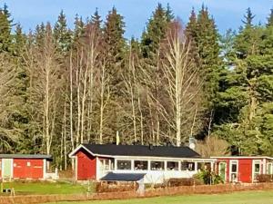 einen roten und weißen Bahnhof mit Bäumen im Hintergrund in der Unterkunft Holiday home NÄSSJÖ III in Nässjö