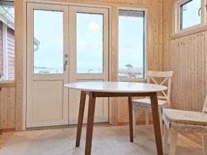 a table and chairs in a room with windows at 2 person holiday home in SÖLVESBORG-By Traum in Björkenäs