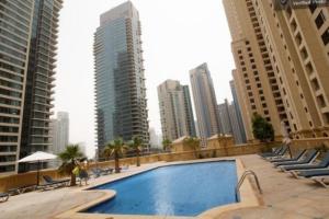 a swimming pool in a city with tall buildings at 2BR Luxury Apartment Marina View in Dubai
