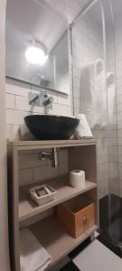 baño con lavabo negro y espejo en Hostal El Lechuguero, en Cascante