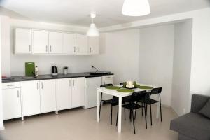 a kitchen with white cabinets and a table and chairs at Porąbka - nocleg w urokliwym miejscu in Porąbka