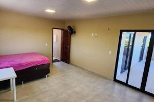 a bedroom with a bed and a table and a window at Casa do Lago in Jacarequará