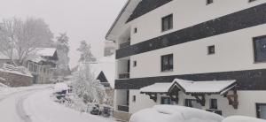 a snow covered street next to a building at Apartman Horizont in Zlatibor