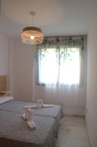 una habitación con una cama con un animal de peluche. en Domus Aura en Nerja