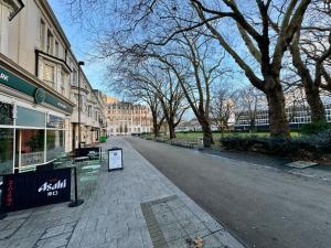 an empty street in a city with trees and buildings at Seafarers Stays in Southampton