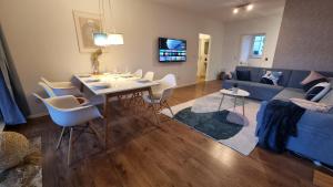 a living room with a table and a blue couch at Archipel Homes neu & gemütlich, zentral, nähe Hamburg und Lüneburg in Geesthacht