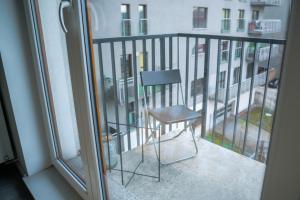 a chair sitting on the balcony of a building at Nowoczesne studio Check in 24h in Wrocław