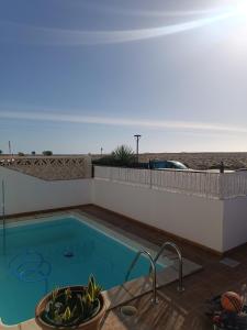 a swimming pool with a view of the ocean at MOANA SURF HOUSE in Corralejo