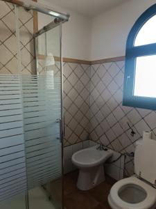 uma casa de banho com um WC e uma cabina de duche em vidro. em MOANA SURF HOUSE em Corralejo