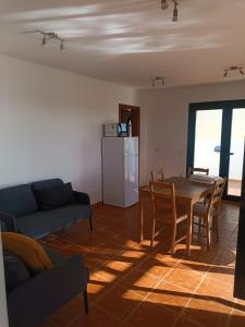 ein Wohnzimmer mit einem Tisch und einem Sofa in der Unterkunft MOANA SURF HOUSE in Corralejo
