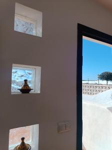 una habitación con dos jarrones en la pared junto a una ventana en MOANA SURF HOUSE, en Corralejo