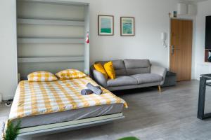 a bedroom with a bed and a couch at Nowoczesne studio Check in 24h in Wrocław