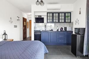 a kitchen with blue cabinets and a bed in a room at Solaris Apartment Nala in Darłowo
