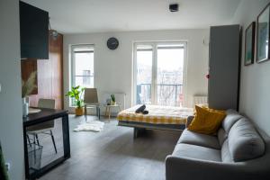 a living room with a couch and a bed at Nowoczesne studio Check in 24h in Wrocław