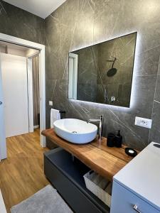 uma casa de banho com um lavatório e um espelho em The Captain's Apartments Marina - next to Verbella - Leonardo Academy, MXP em Sesto Calende