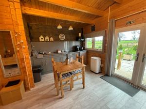a kitchen with a wooden table and a dining room at Rife Lodges in Arundel