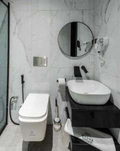 a bathroom with a sink and a toilet and a mirror at DLUXE PREMIUM HOTEL in Port Harcourt